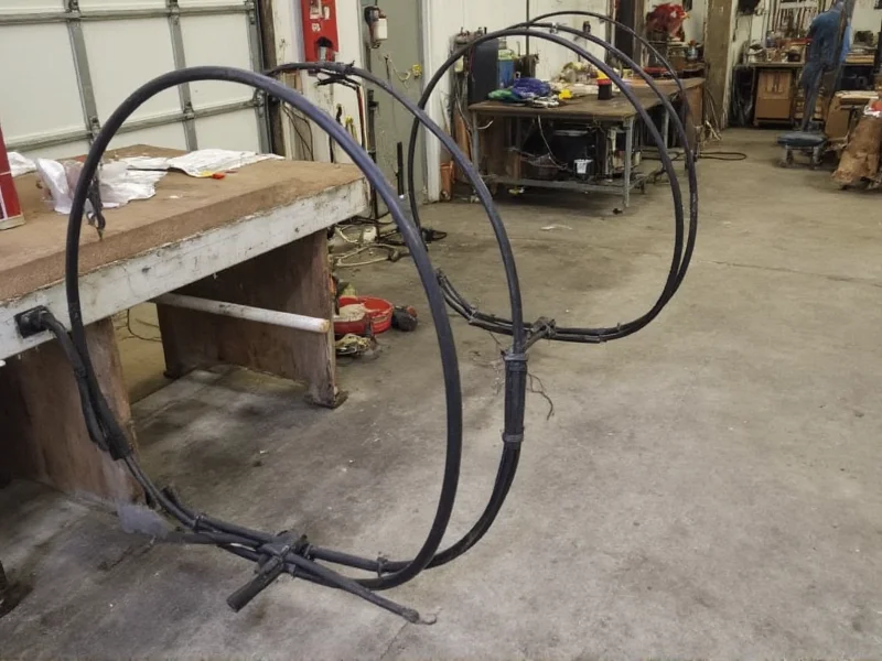 Steel hoops being shaped around pipe for barrel construction