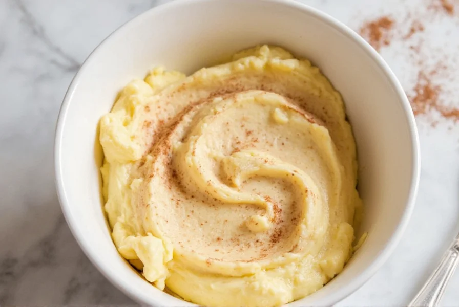 Homemade cinnamon butter in a small ceramic bowl with cinnamon sticks and fresh bread slices