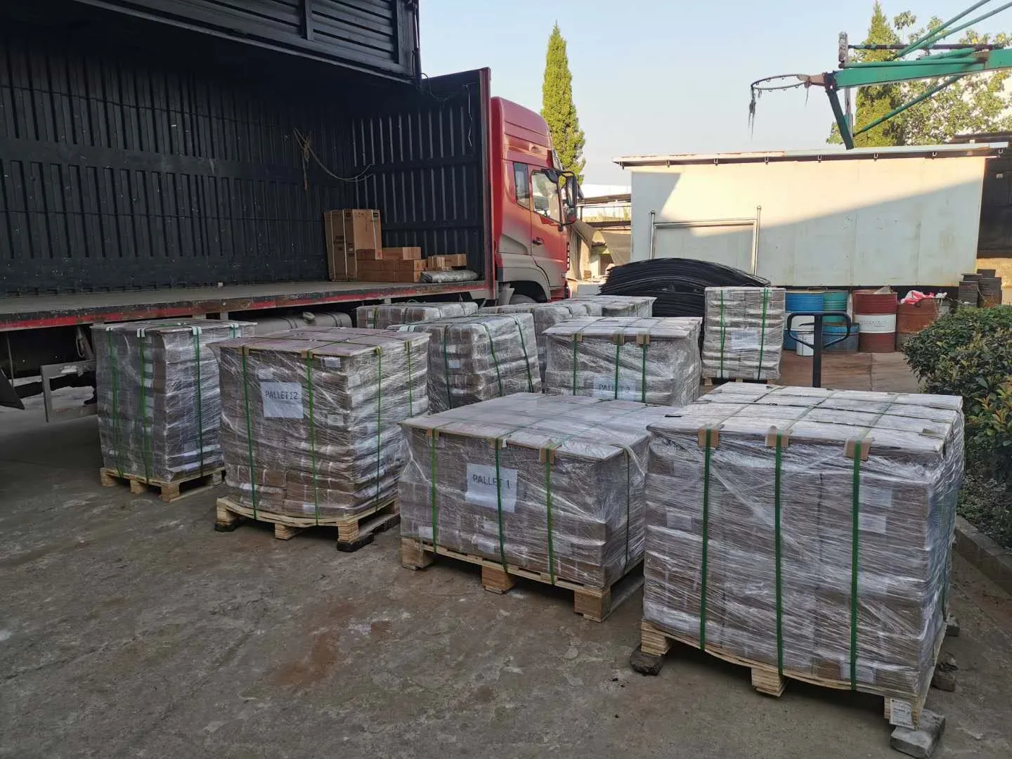 Wrapped pallets of goods beside a truck for loading