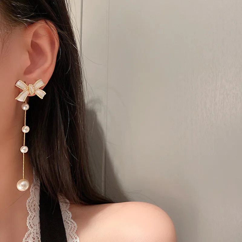 

11cm long gold bow earring with pearl
