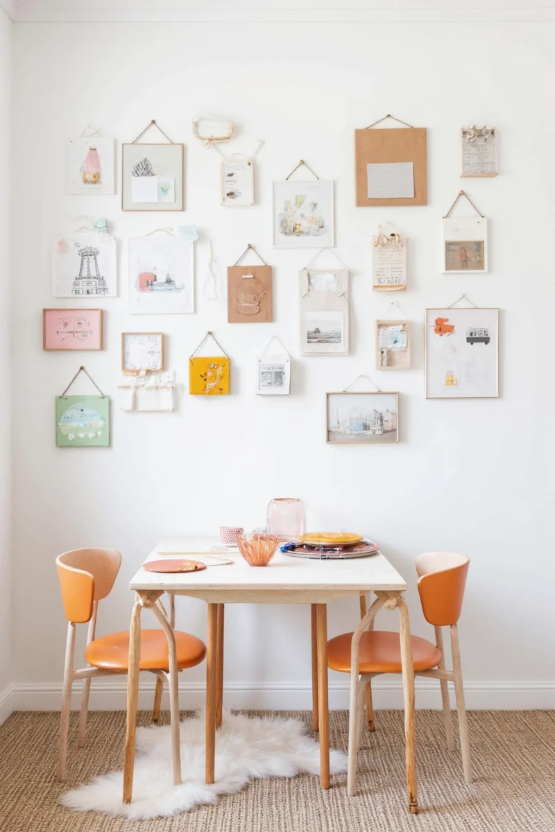 Kids drawing on a large whiteboard-style wall panel