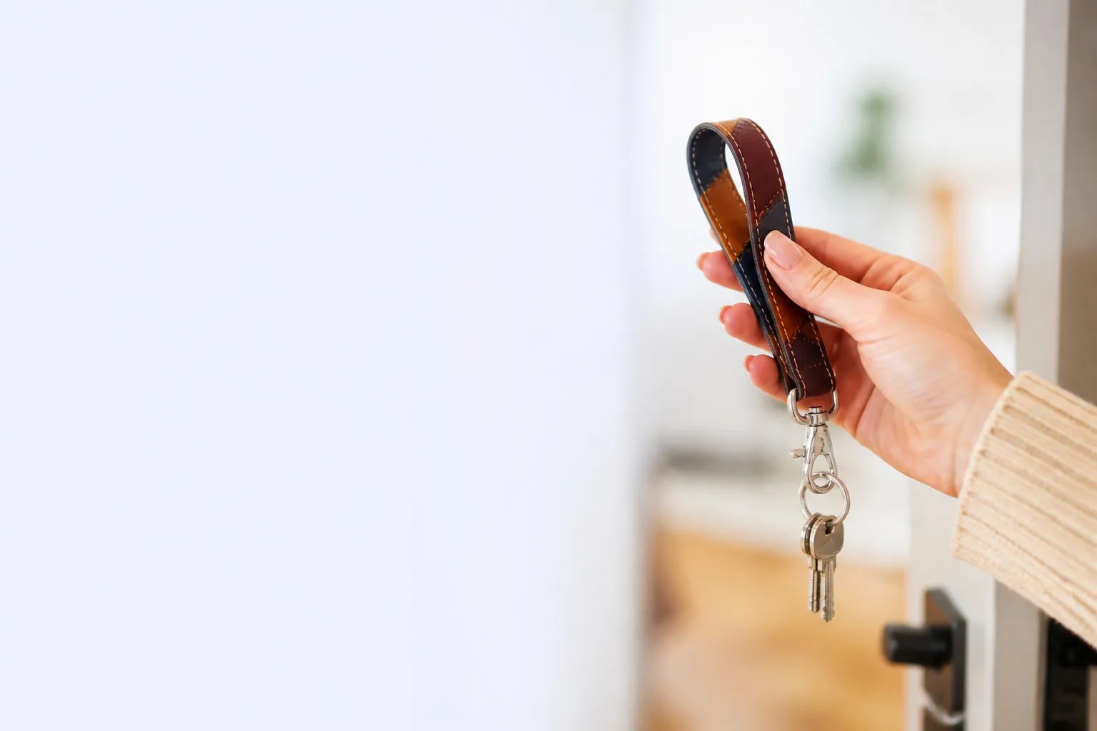 Leather wrist strap keychain in use, keys hanging from clasp