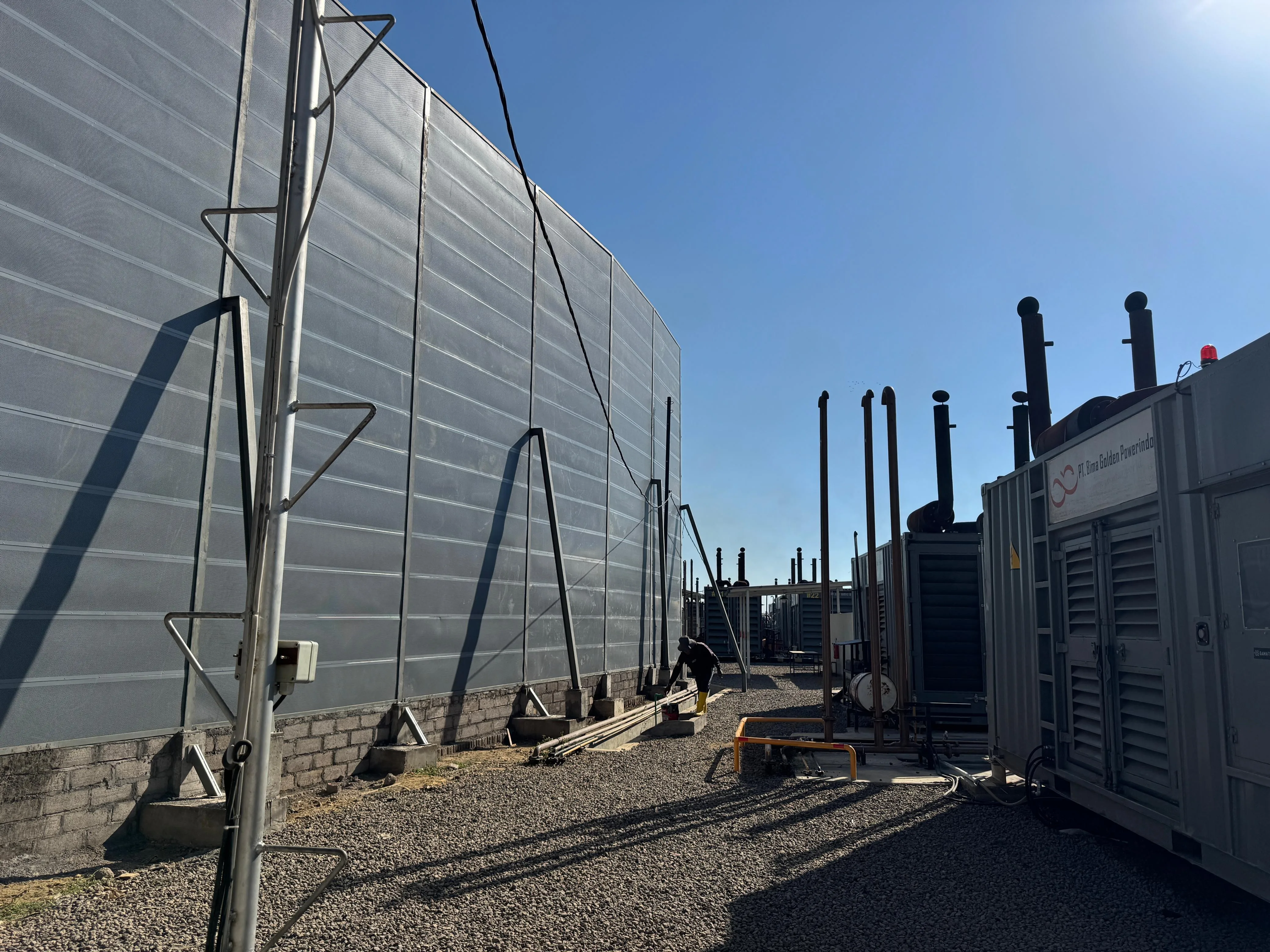 Close view of micro-perforated metal noise barrier panels and structural supports
