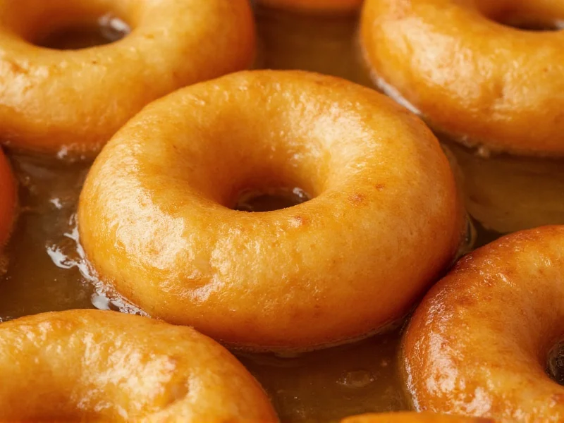 Close-up of donut frying in oil showing perfect golden color