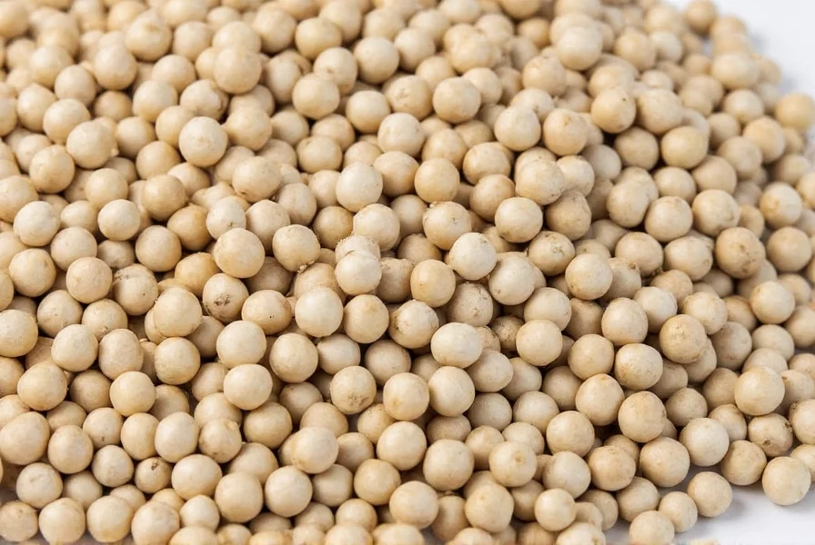 Chef grinding whole white peppercorns in a manual pepper mill