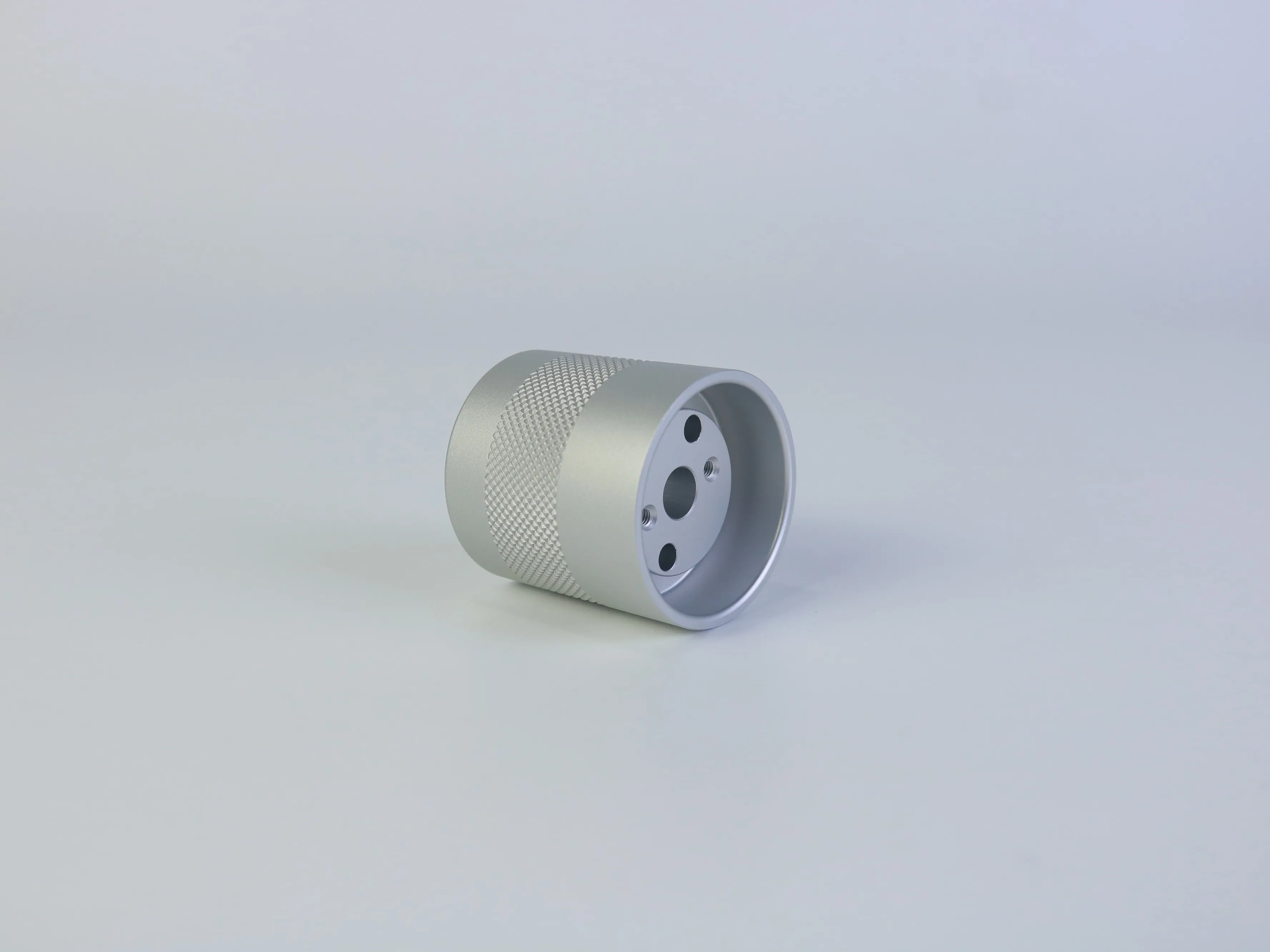 Side view of a turned aluminum housing with diamond knurling and internal cavity