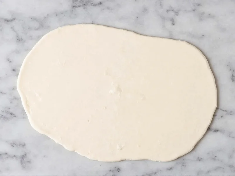 Smooth homemade fondant rolled on marble surface