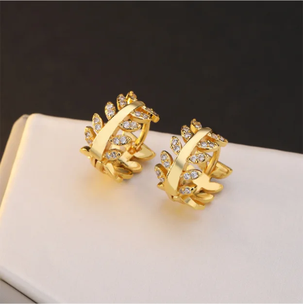 

earrings jewellery in leaf shape shiny gold huggies earrings for women