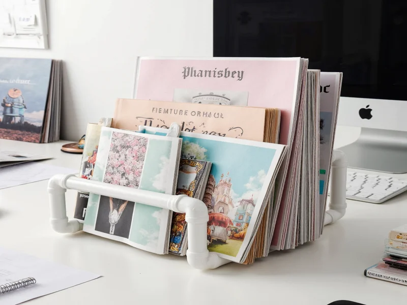 DIY PVC pipe organizer holding magazines and notebooks on desk
