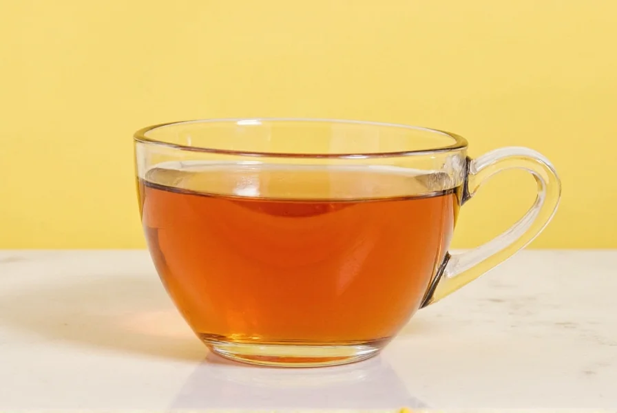 Fresh ginger root slices steeping in clear glass teapot with steam rising