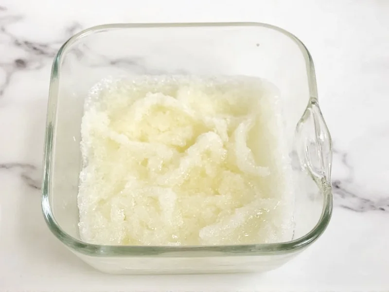 Natural sugar scrub in glass bowl with coconut oil