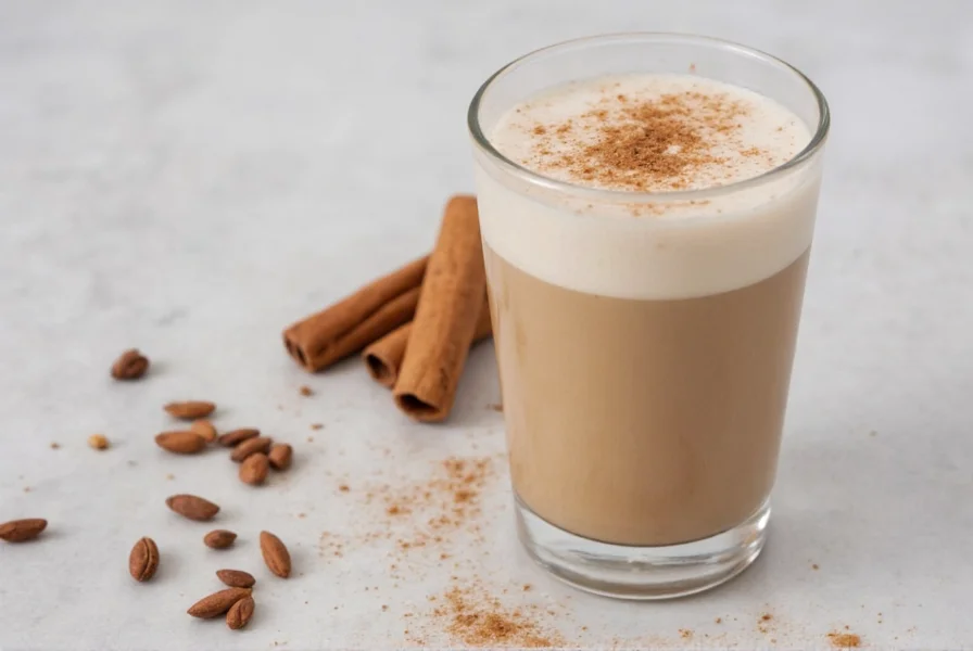 Bottle of homemade cinnamon coffee creamer next to coffee cup with cinnamon sprinkle