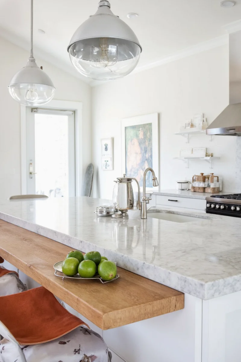 Two pendant lights above a wooden kitchen island with stools