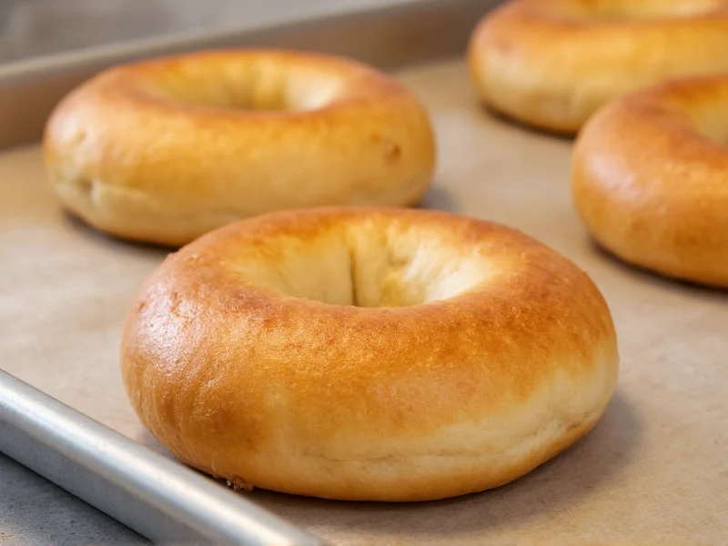 Homemade bagels golden brown on baking sheet