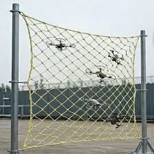 Aramid anti drone net hung between two posts with several multirotors caught in the mesh