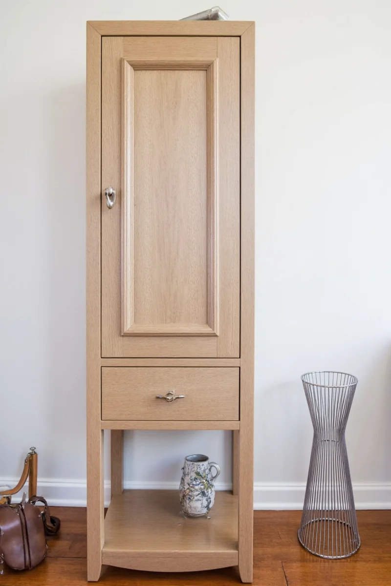 Detail shot of a tall cabinet showing adjustable shelves and soft-close hinge mechanism.