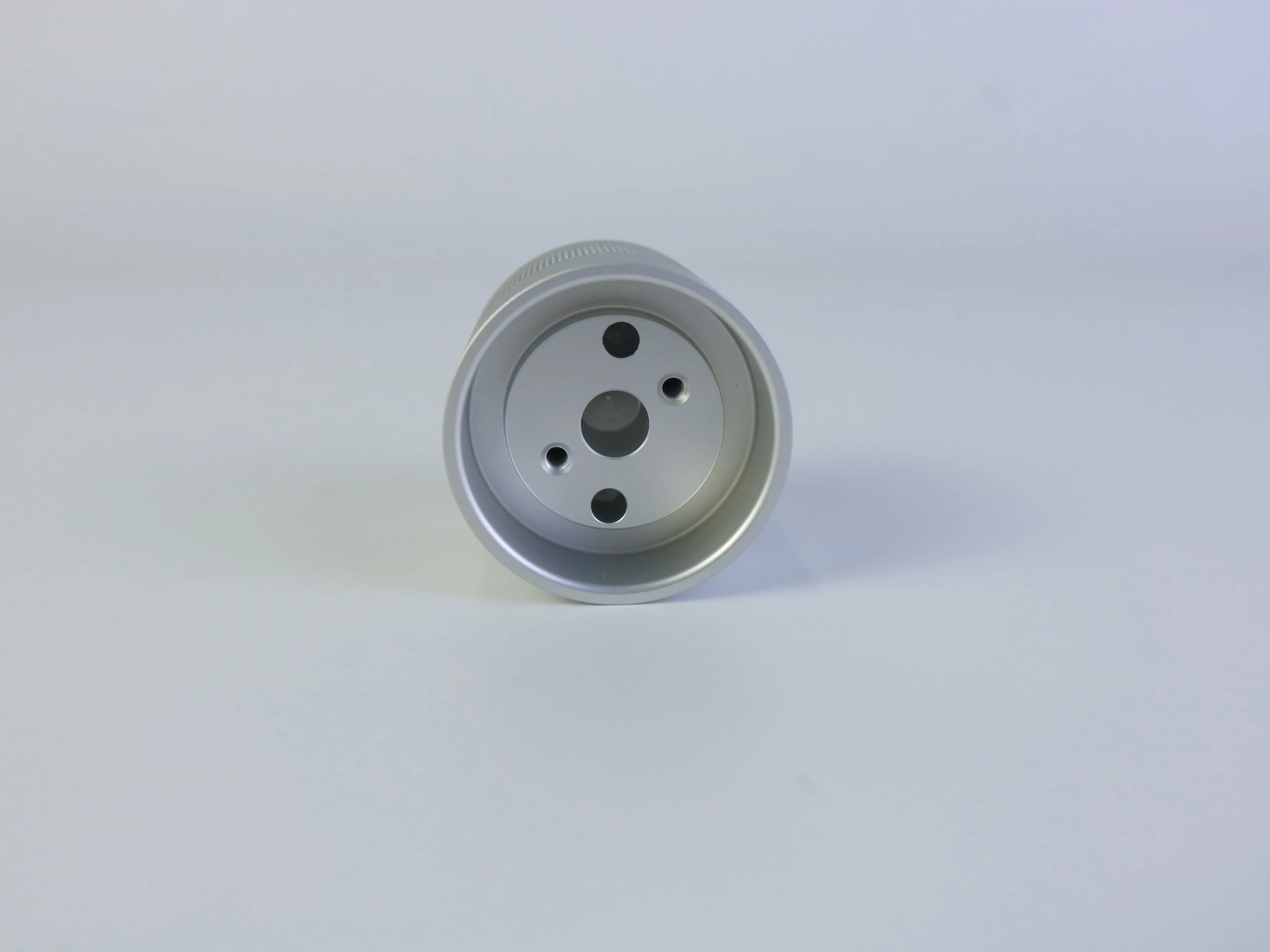 End face of a custom CNC aluminum housing with central opening and mounting holes
