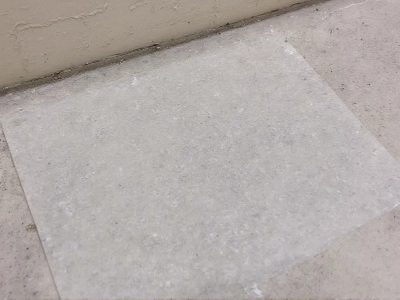 DIY moisture test showing plastic sheet on concrete