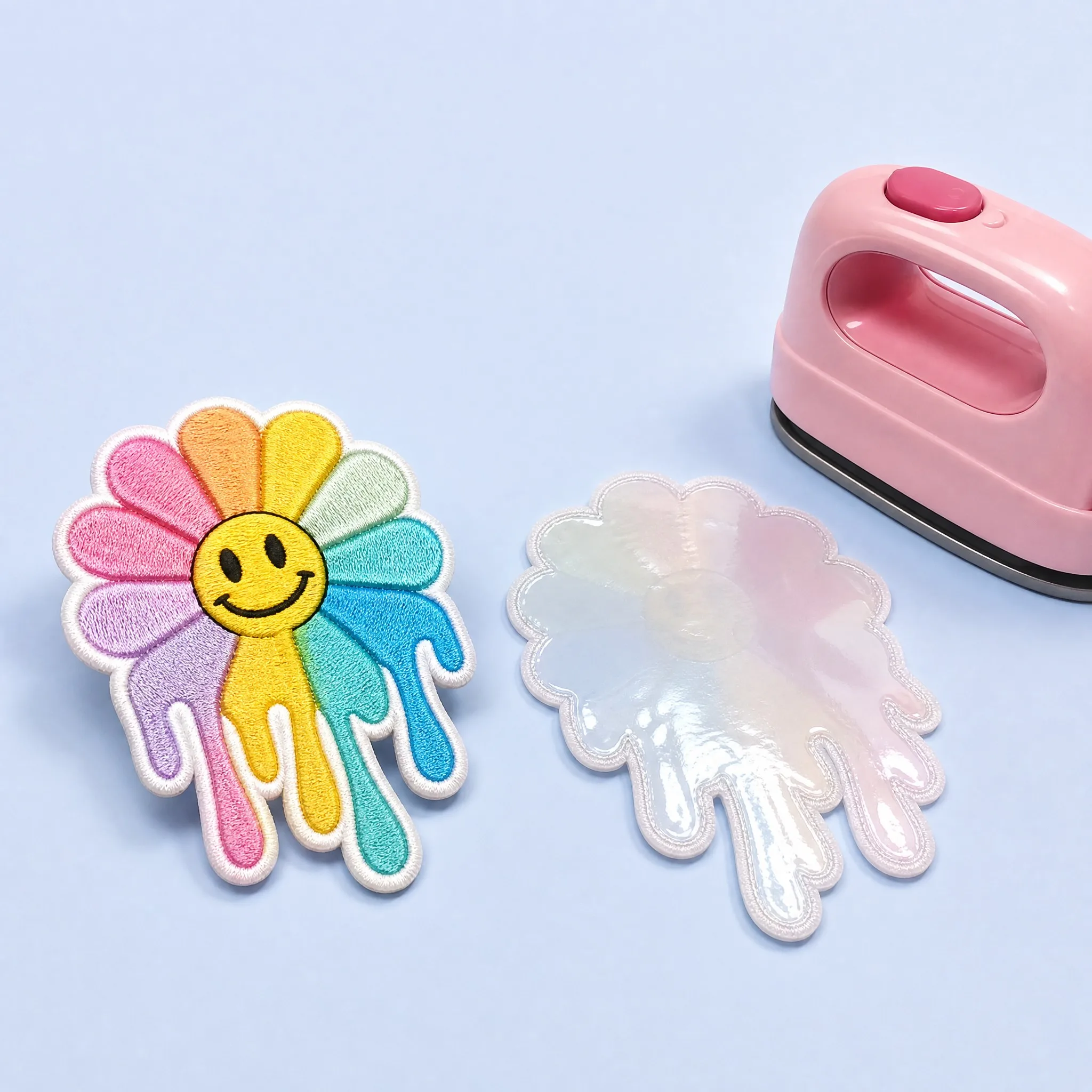 Pastel Rainbow Melting Daisy Patch Front alongside Smooth Transparent Heat-Seal Iron-On Backing and Pink Mini Craft Heat Iron