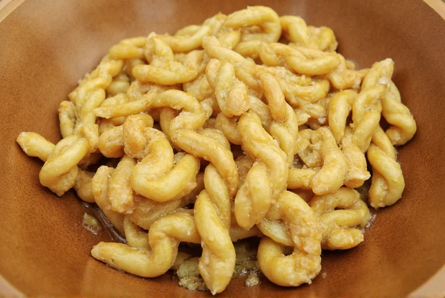 Professional chef demonstrating twisted ginger technique with fresh ginger root on wooden cutting board