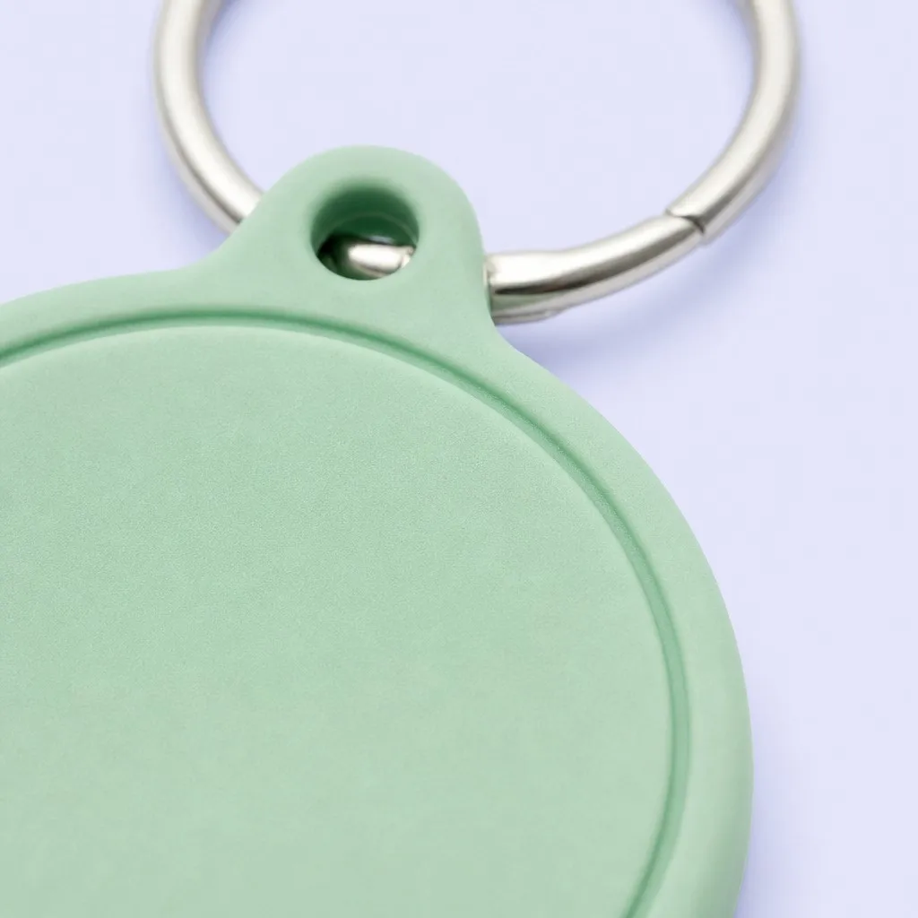 Angled close-up of a mint green keychain tag with silver ring