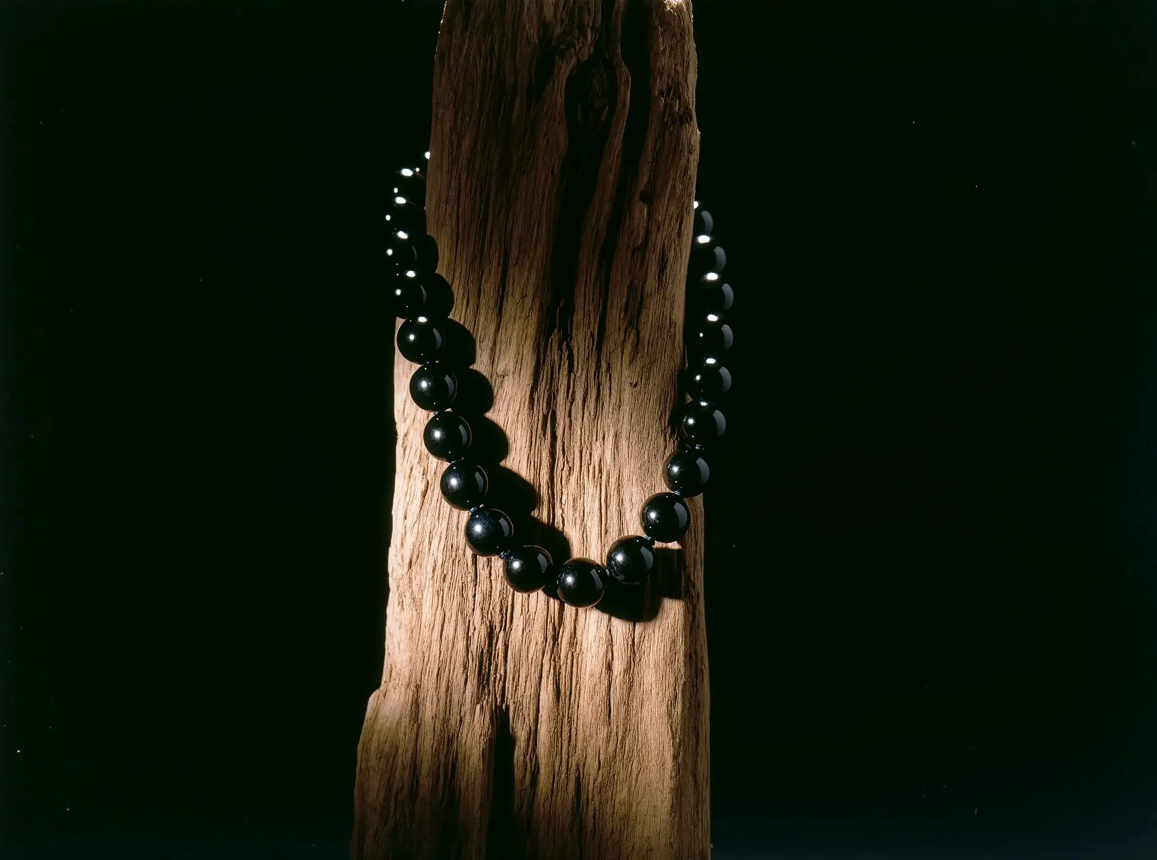 A visual manifesto of Sovereign Stillness Jewelry Stewardship: Handcrafted obsidian relics on reclaimed natural driftwood.