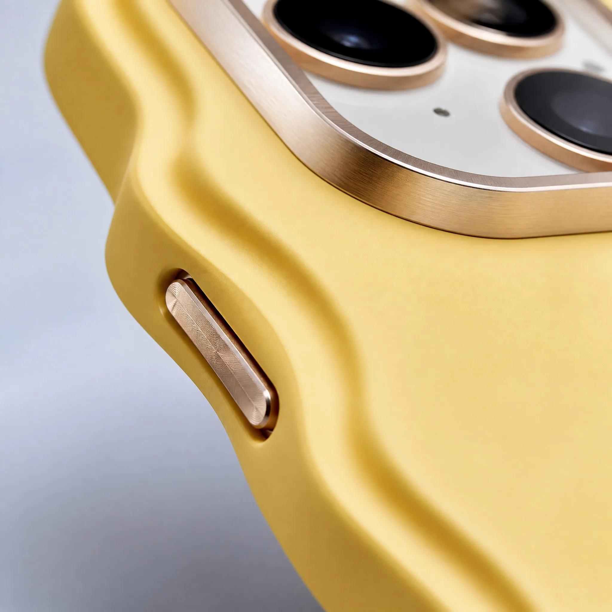 4K Macro Close-up of Anodized Aluminum Camera Bezel Lip and Independent Tactile Metallic Power Button on Wavy Phone Case
