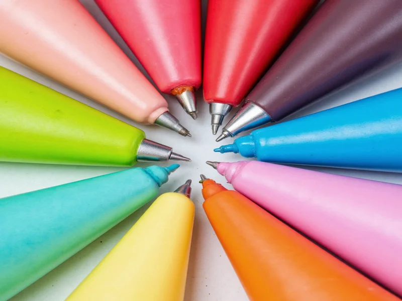 Colorful icing samples in pastry bags with different tips