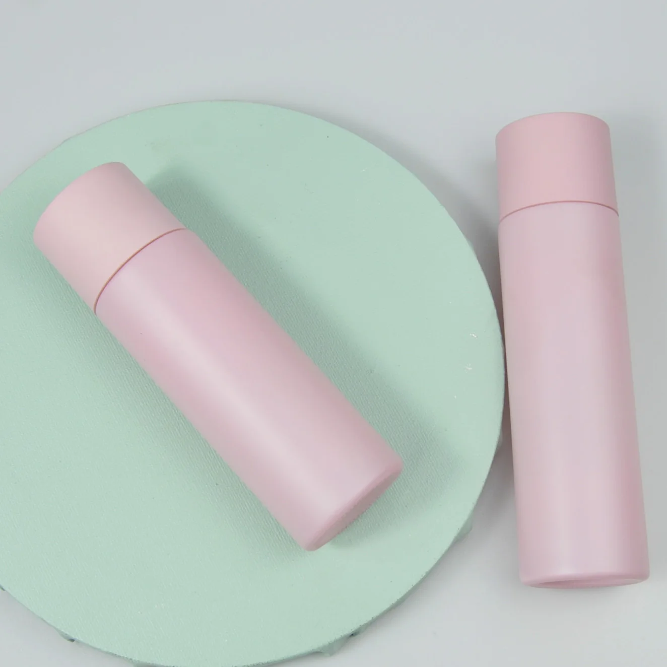 

Empty round glass pink lotion bottle skin care packaging with pump for cosmetic cream