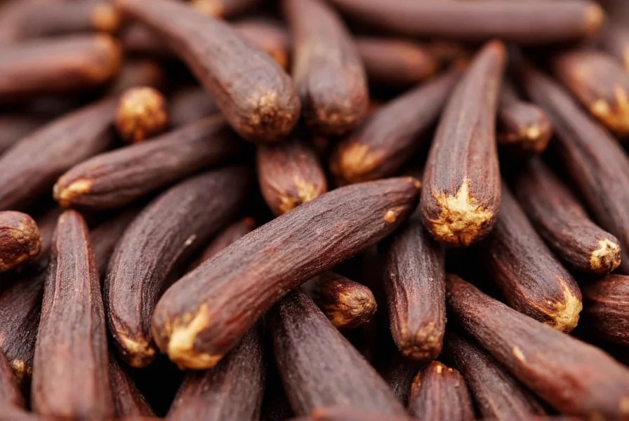 Close-up photograph of whole cloves showing nail shape, reddish-brown color, and visible oil glands on the surface