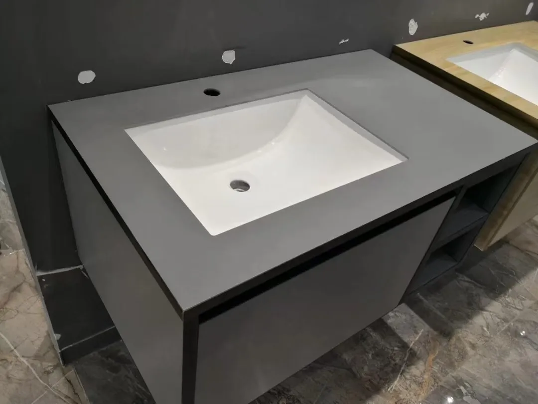 Dark grey quartz bathroom vanity top with white rectangular undermount basin and faucet hole