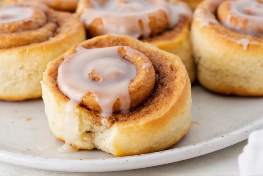 Freshly baked Publix cinnamon rolls with melted icing on a ceramic plate