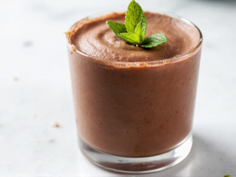 Silky dark chocolate mousse in glass with mint garnish