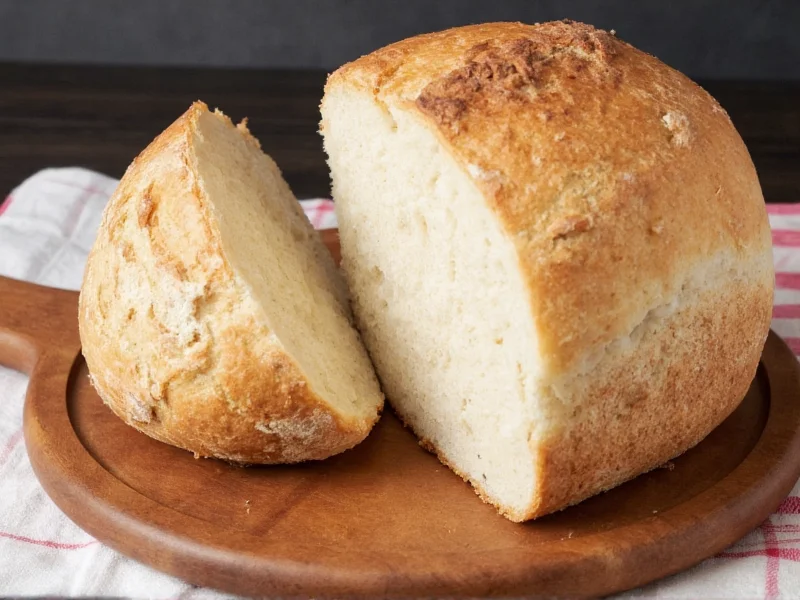 Homemade sourdough loaf stored cut-side down on wooden board