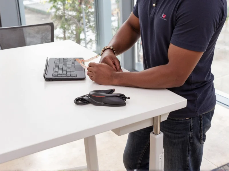 Person measuring elbow height for standing desk setup