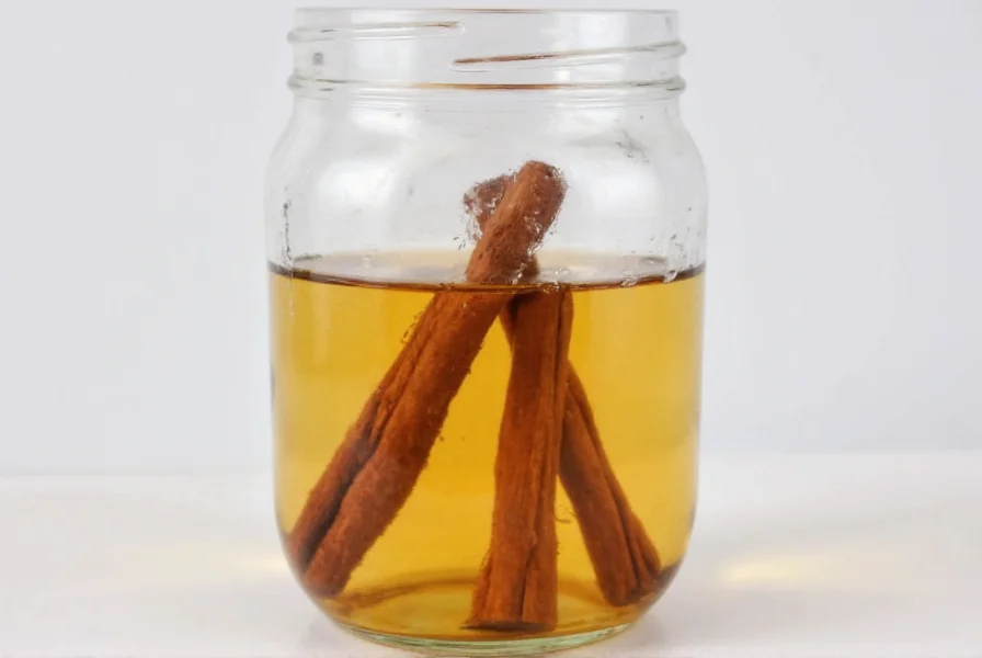 Glass jar with cinnamon sticks steeping in clear liquid for homemade extract