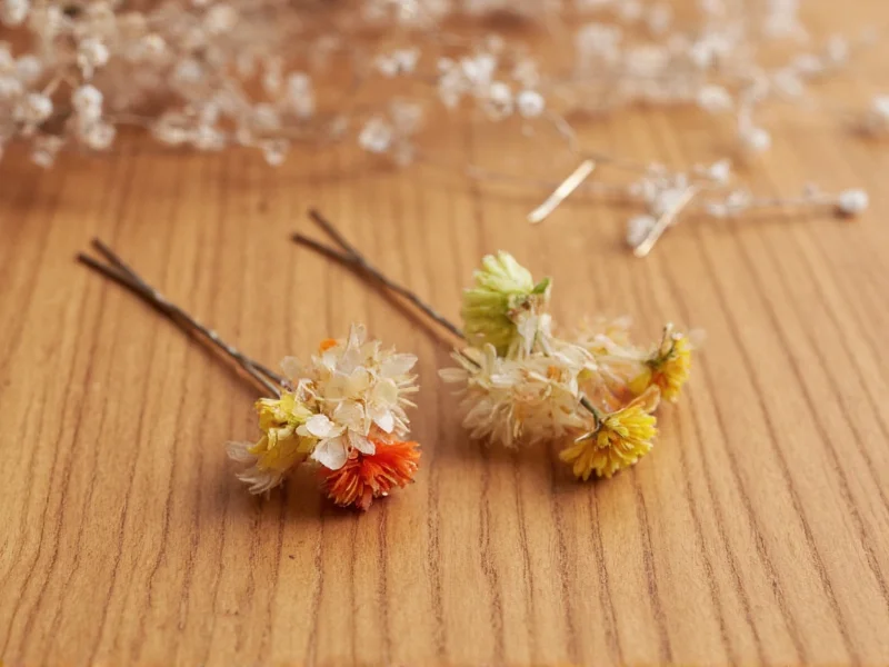 Handmade strawflower hair pins on wooden surface
