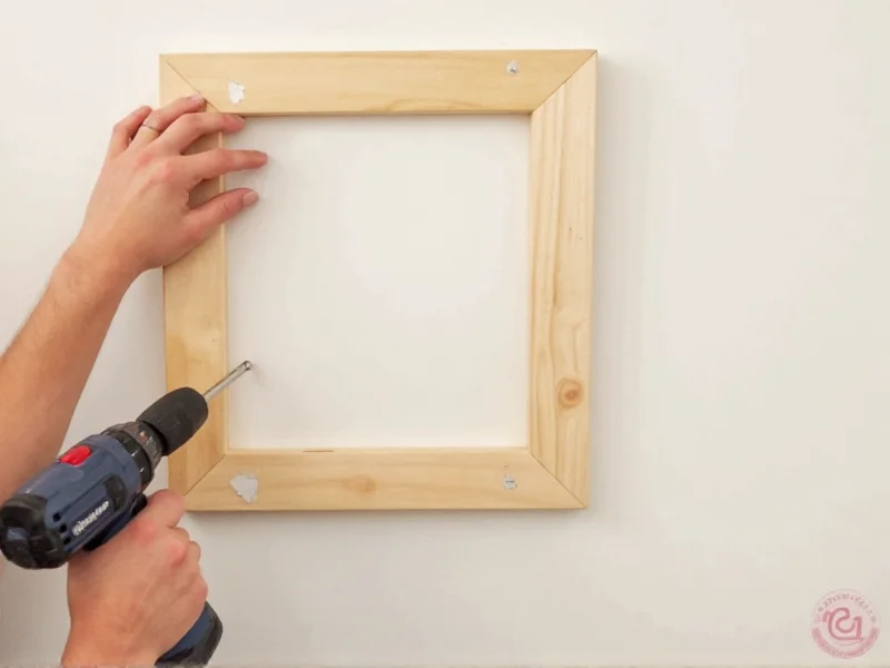 Hand holding drill attaching diy hall tree frame to wall studs