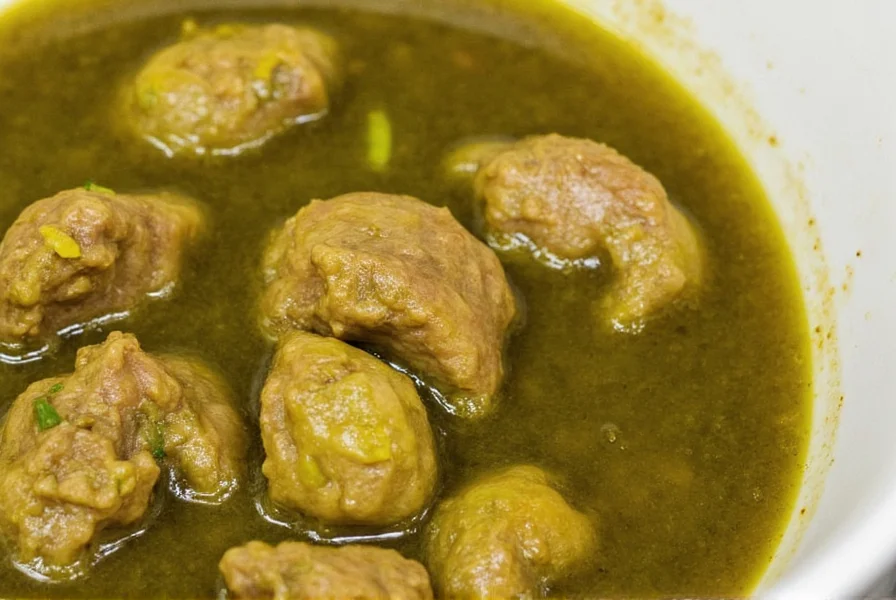 Close-up of perfectly cooked pork green chili stew showing tender meat and vibrant green broth