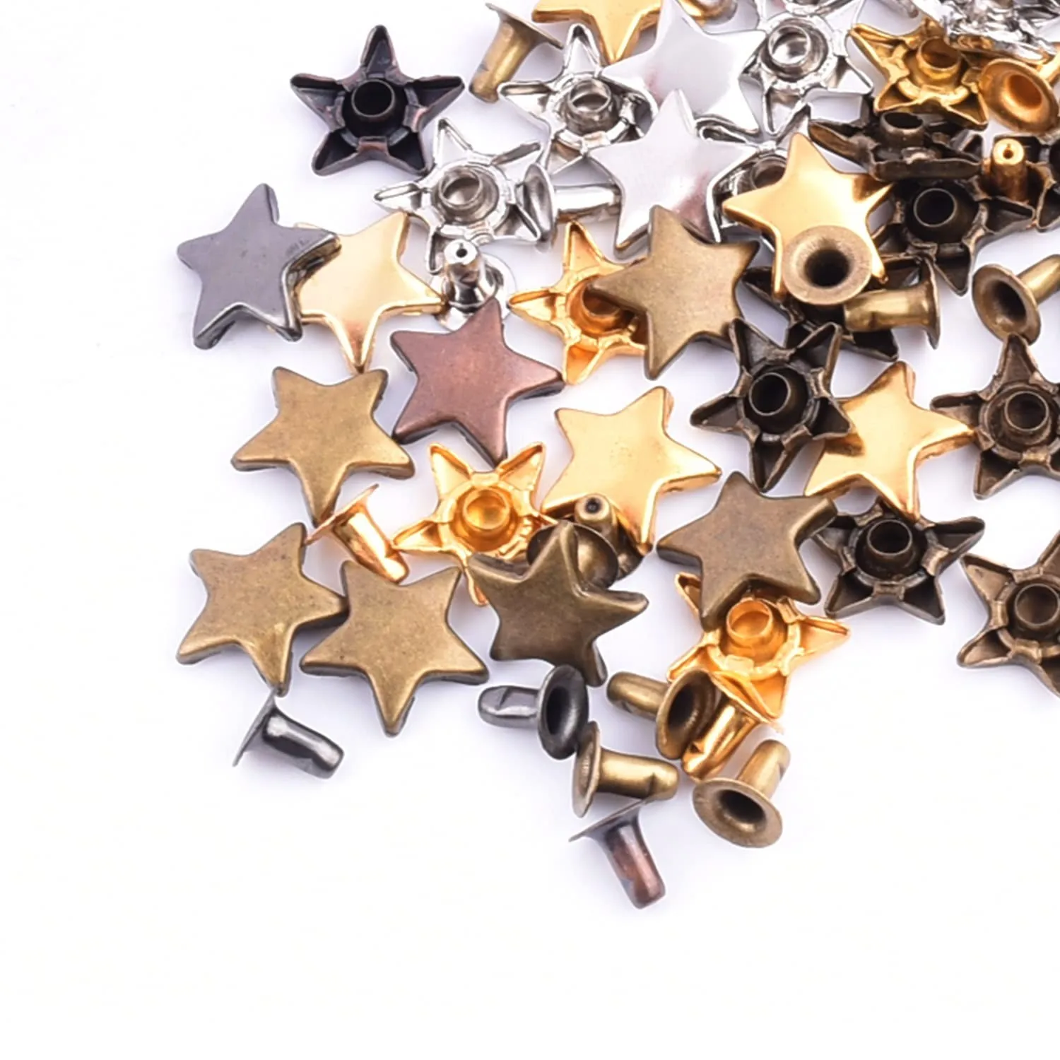 Solid brass rivets bulk &mdash; star-shaped and dome-head fasteners in multiple metallic finishes, scattered on white background