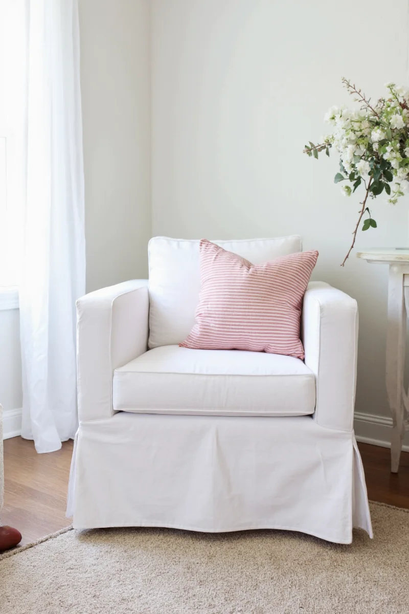 Family sitting on slipcovered white chairs in a living room