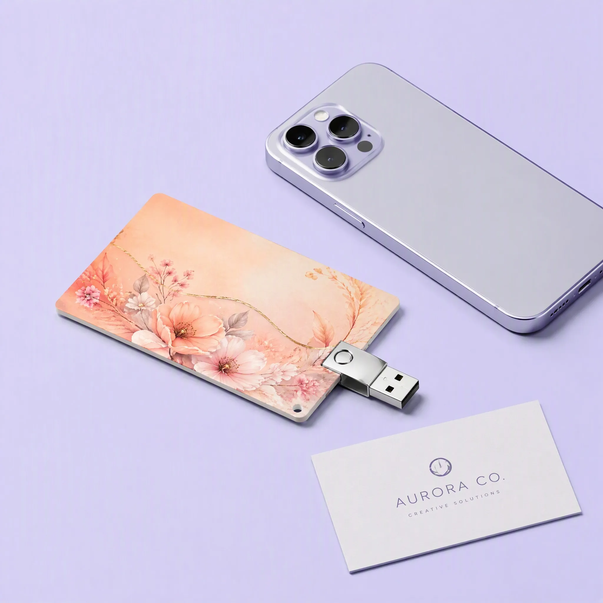 Modern Tech Setup with Lavender iPhone Pro, White Creative Studio Business Card, and Peach Floral Card USB Drive