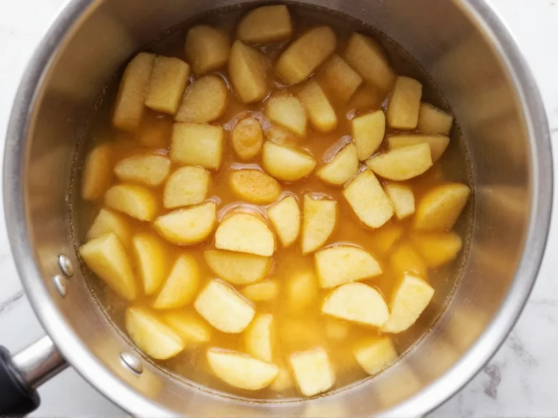 Simmering apples in stainless steel pot for applesauce