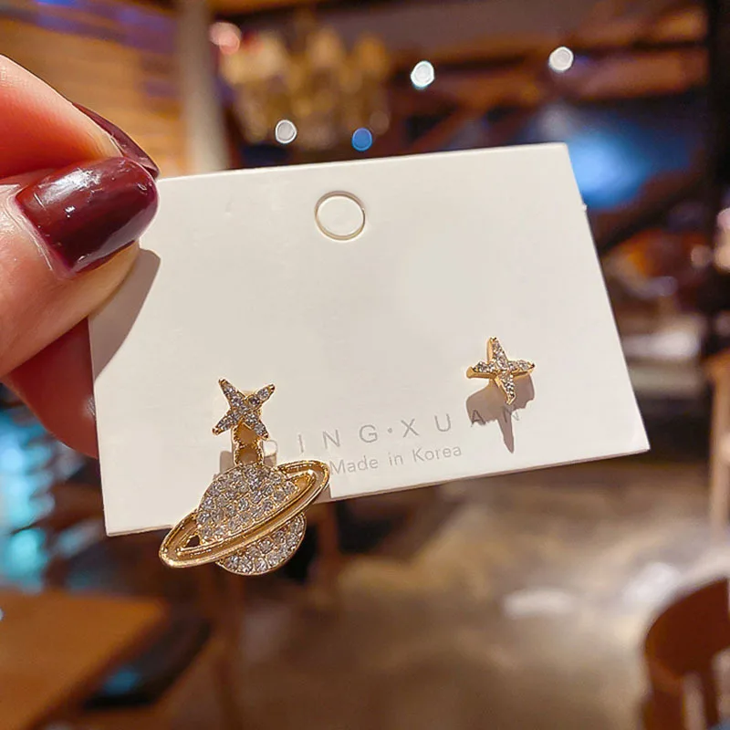 

Asymmetric earrings with simple diamond-encrusted star earth pendant