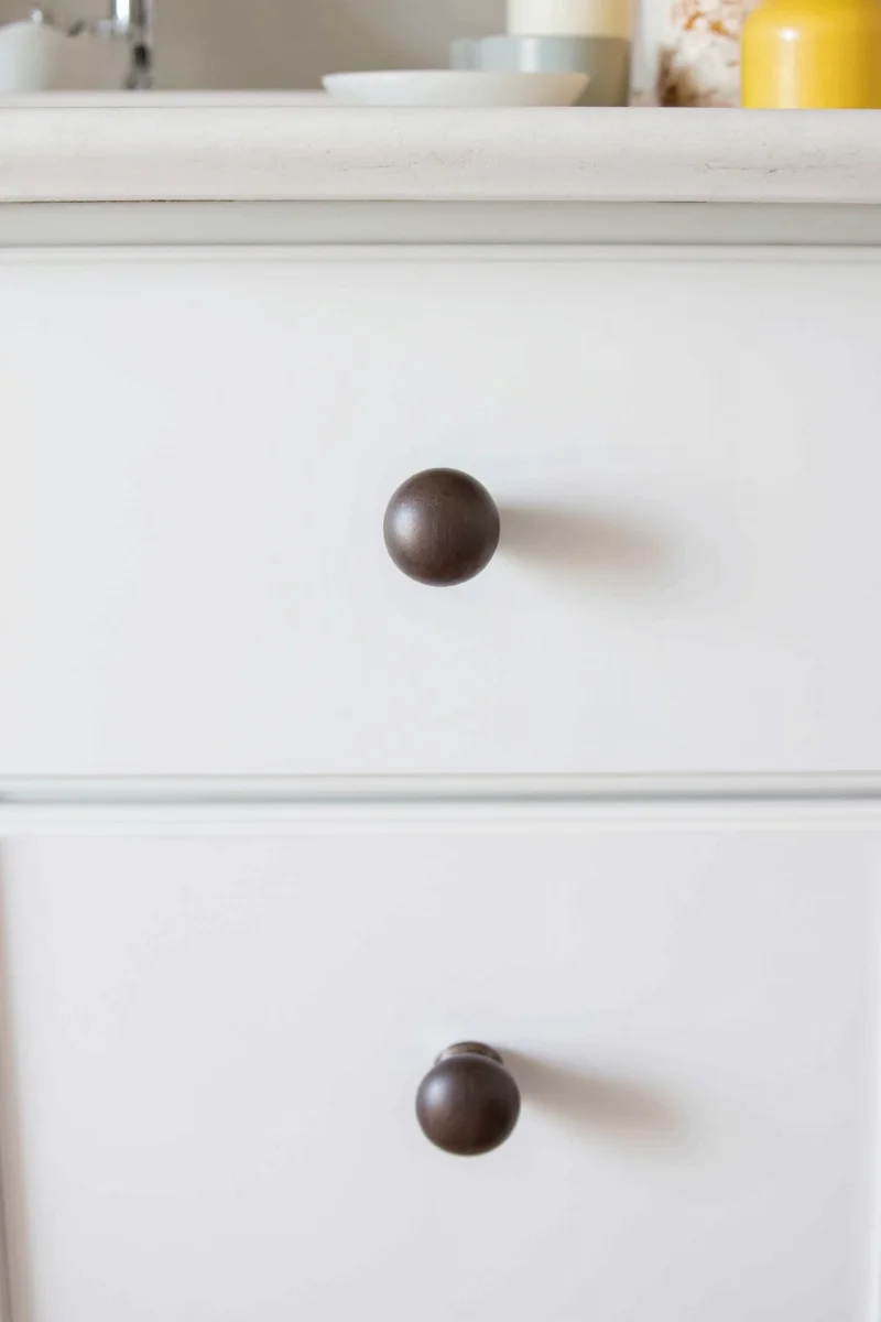 White kitchen cabinets with various knob styles