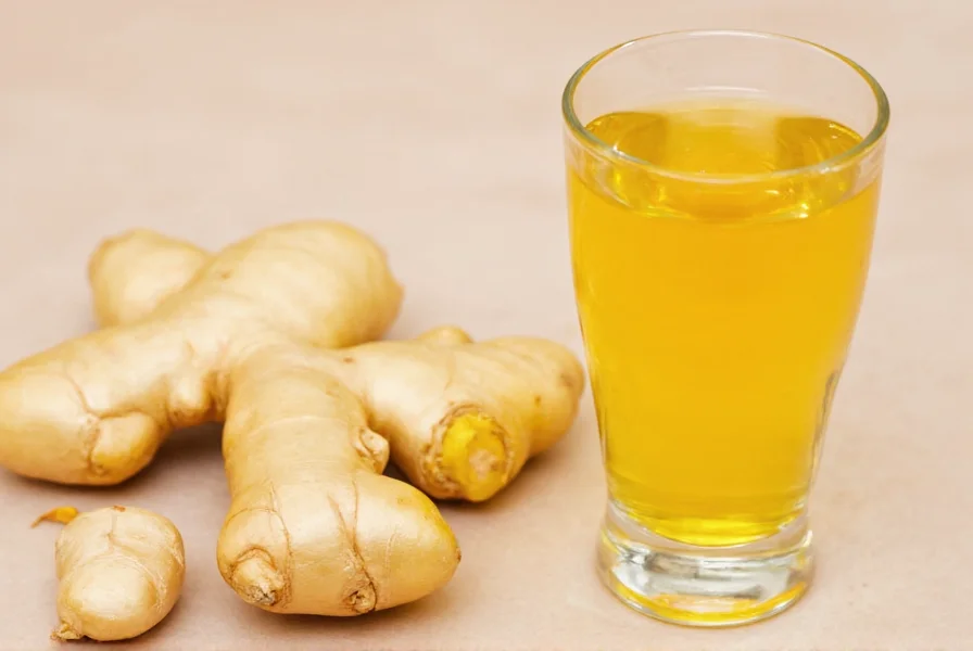 Glass containing golden ginger shot next to fresh ginger root