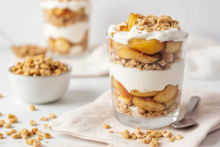Layered no-bake apple cinnamon dessert in glass showing yogurt, sauteed apples, and granola
