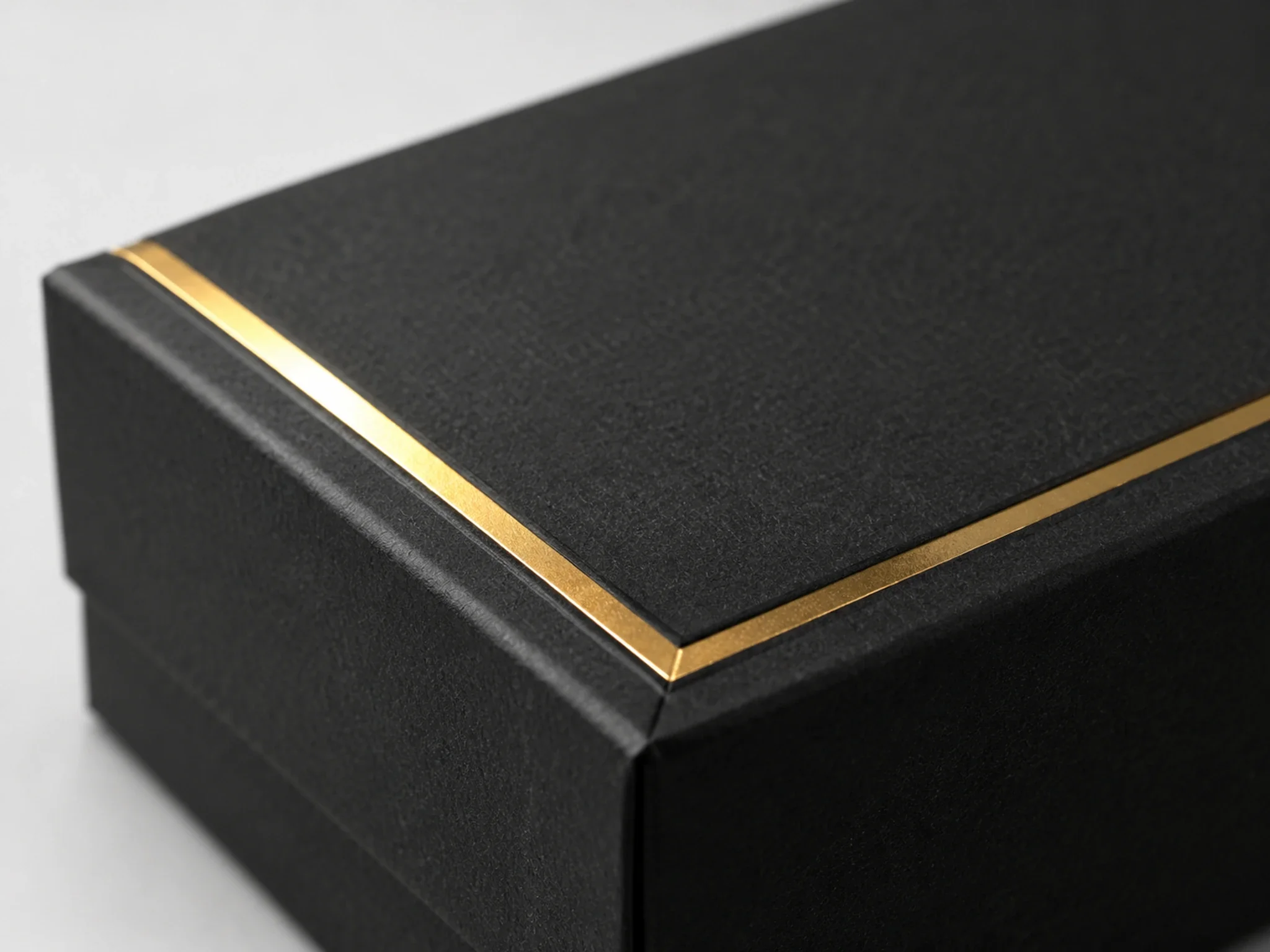 Gold foil stamped border on a black tarot box lid seen in raking light