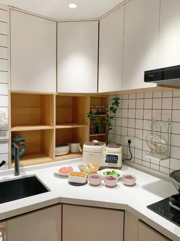 White quartz kitchen countertop with black undermount sink and warm wood open shelving