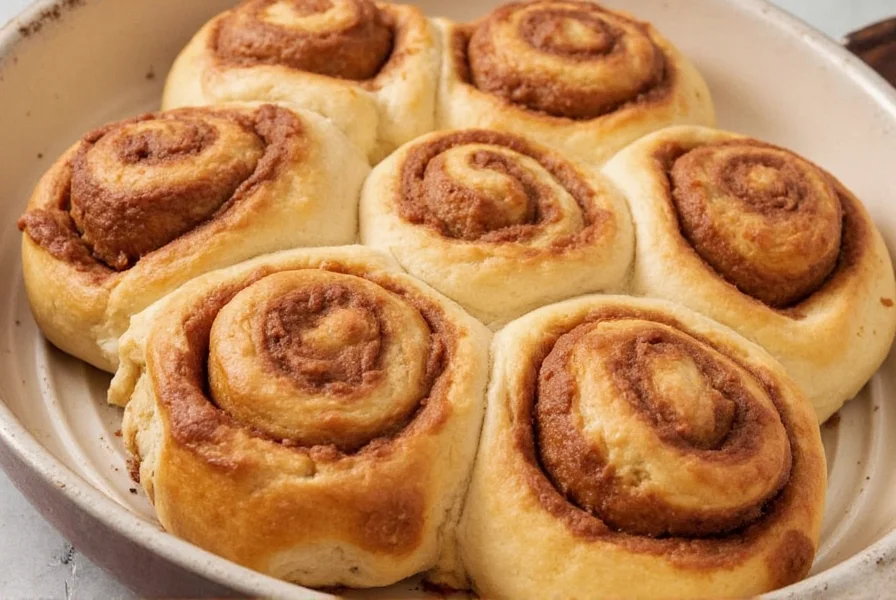 Professional baker shaping oversized cinnamon roll dough in a commercial kitchen